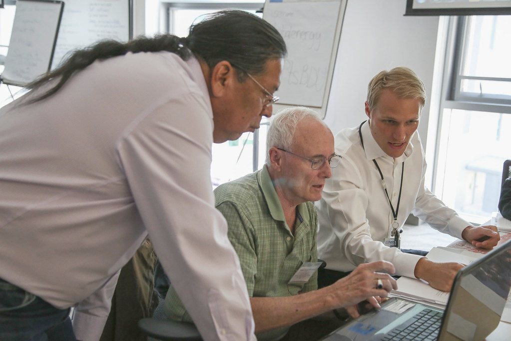Colleagues working together at laptops by a window
