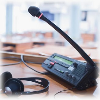 A conference microphone and headset on a desk